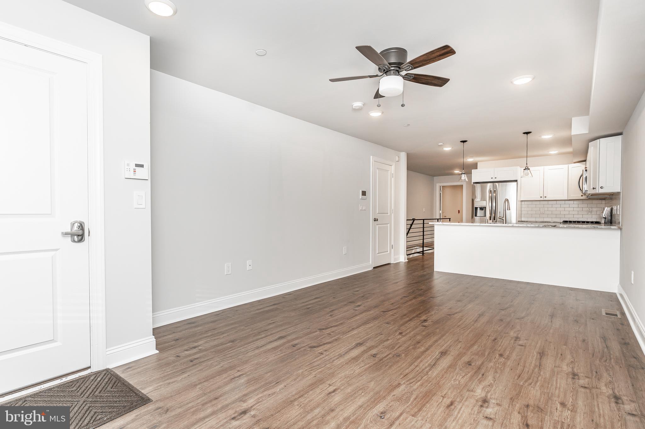 a view of a kitchen with a sink and wooden floor