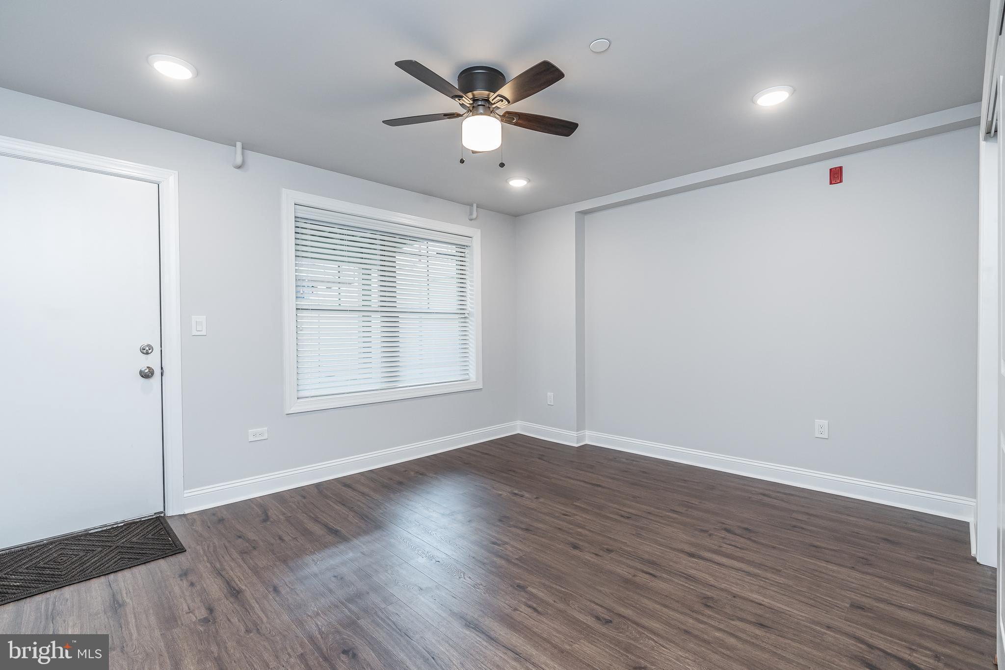 2202 Christian Street, Unit 1 Philadelphia, PA 19146 - Photo 13 of 27 an empty room with wooden floor and windows