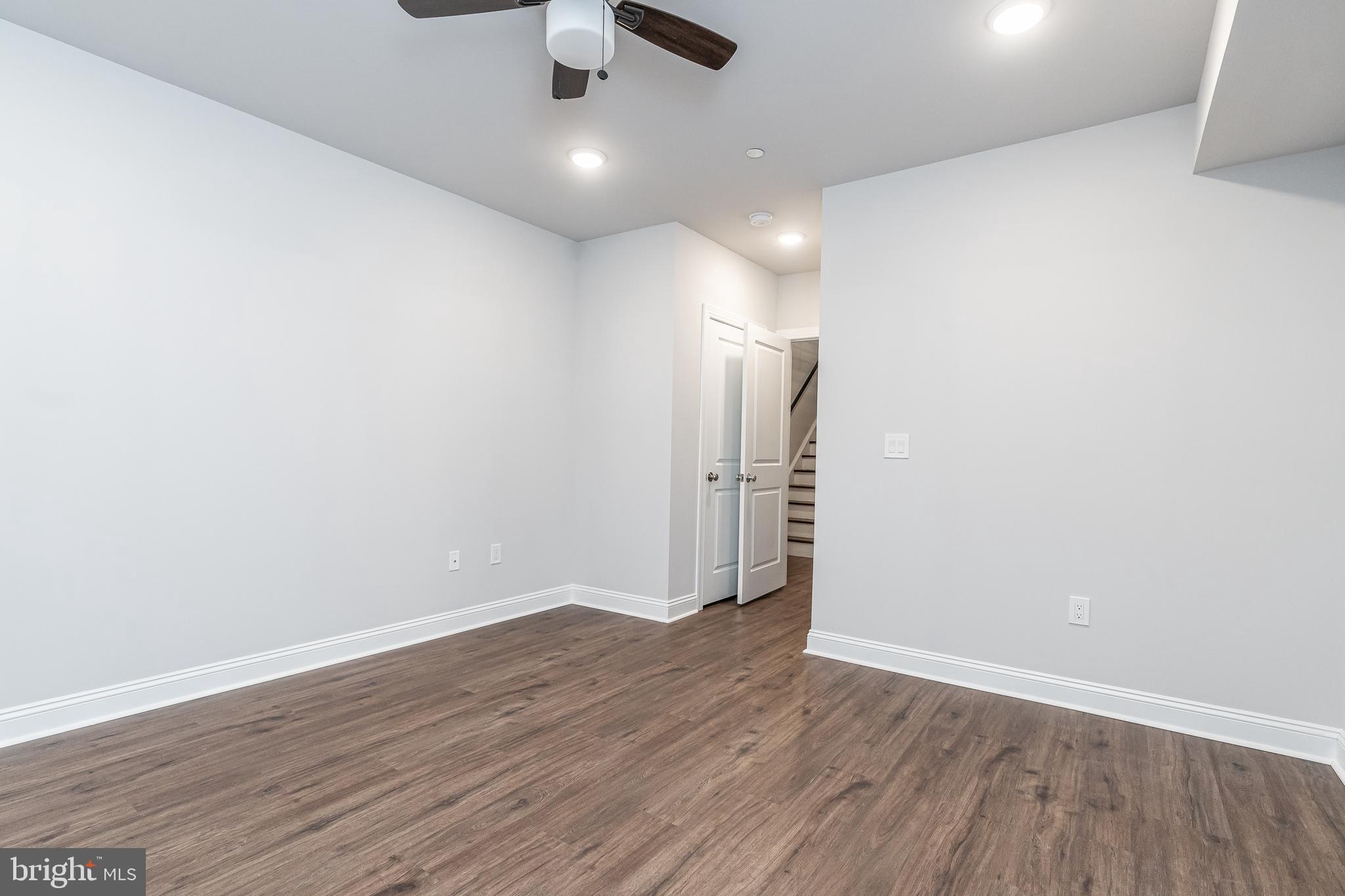 2202 Christian Street, Unit 1 Philadelphia, PA 19146 - Photo 19 of 27 an empty room with wooden floor ceiling fan and windows