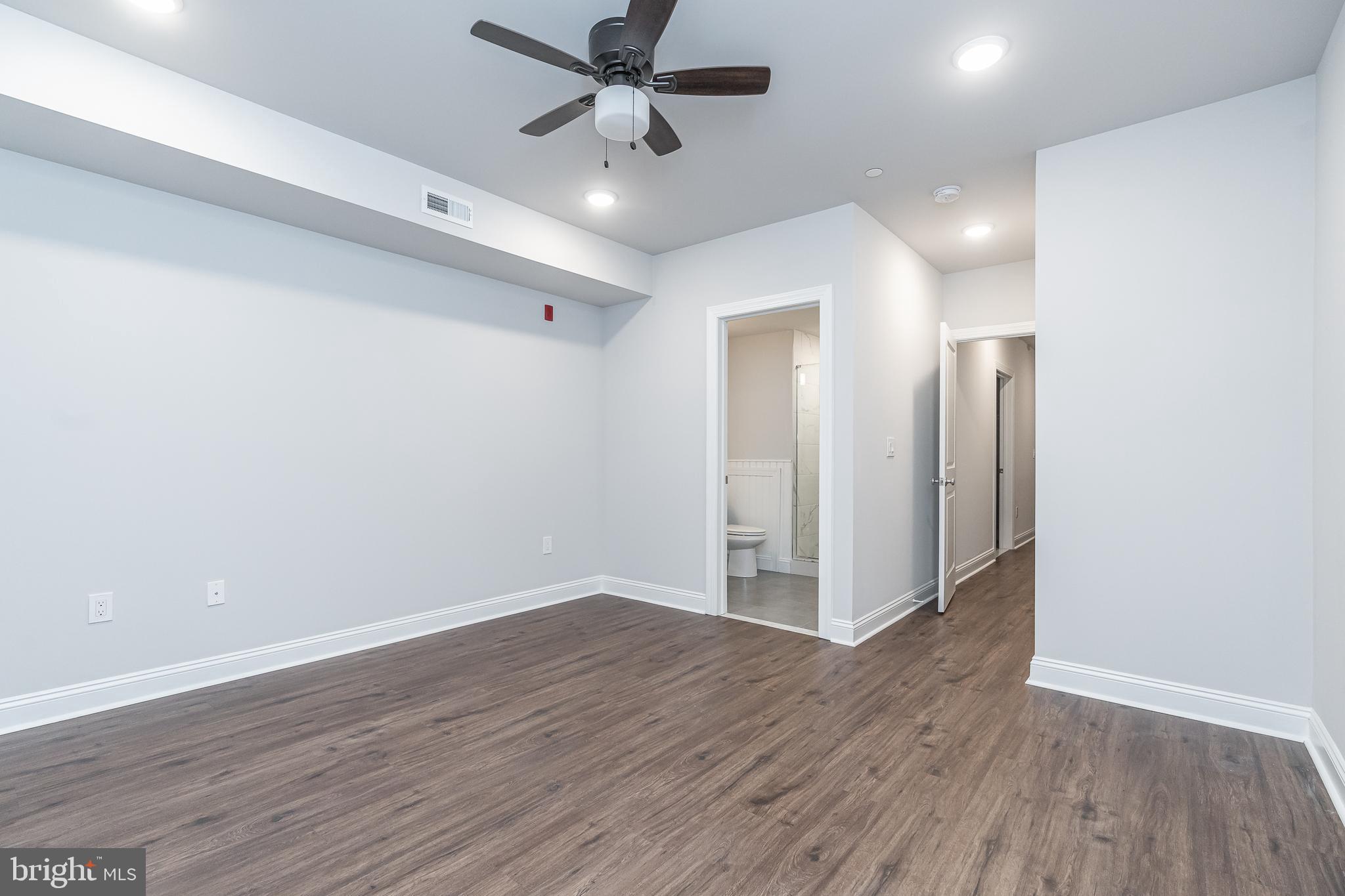 2202 Christian Street, Unit 1 Philadelphia, PA 19146 - Photo 25 of 27 an empty room with wooden floor a ceiling fan and closet
