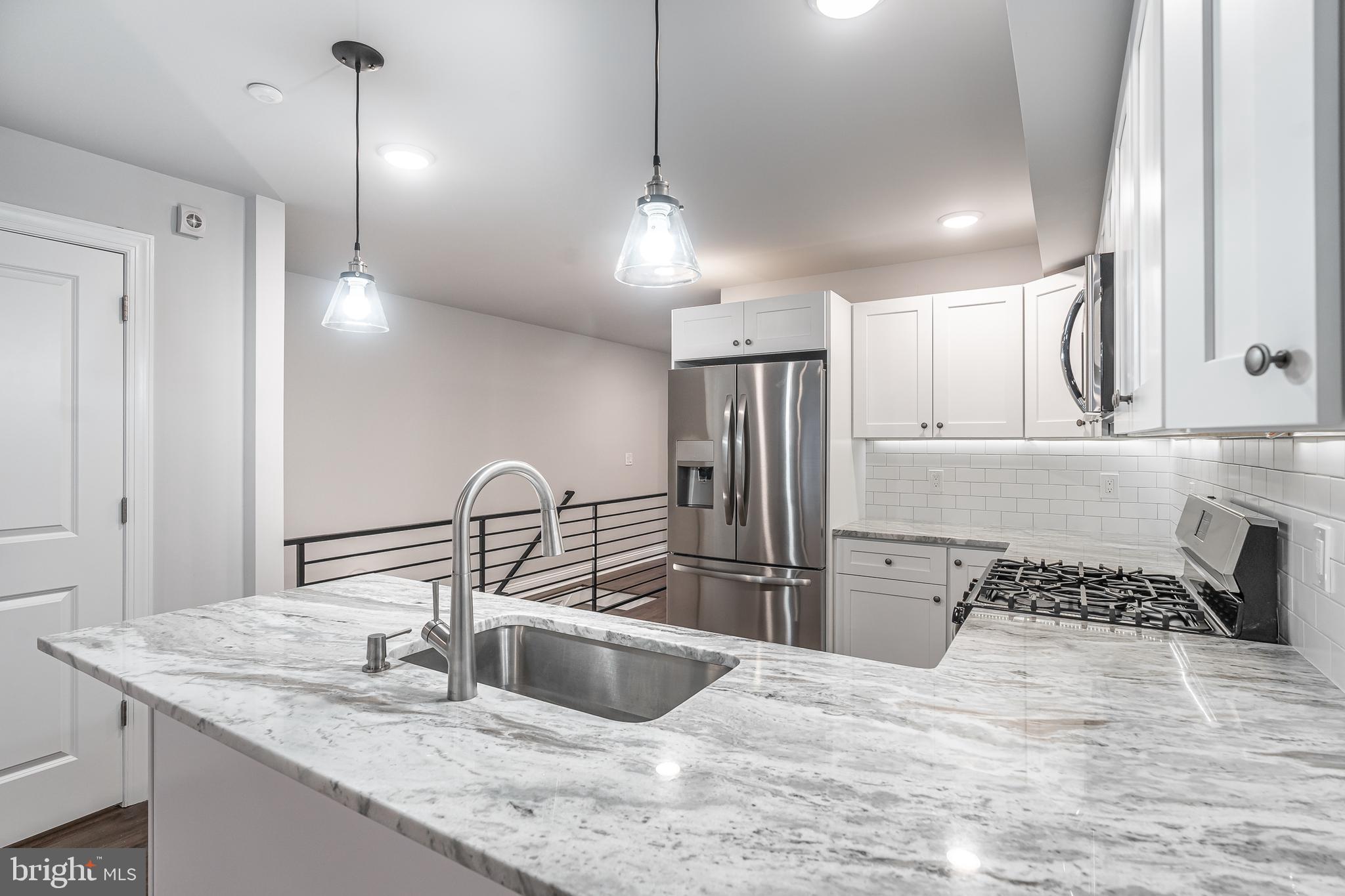 2202 Christian Street, Unit 1 Philadelphia, PA 19146 - Photo 8 of 27 a kitchen with granite countertop a sink stainless steel appliances and cabinets