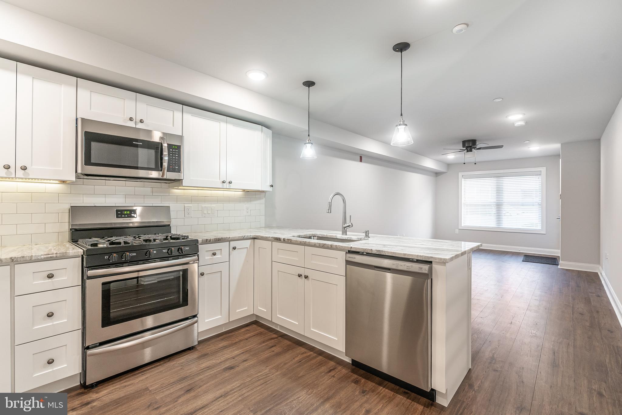2202 Christian Street, Unit 1 Philadelphia, PA 19146 - Photo 9 of 27 a kitchen with stainless steel appliances granite countertop a stove a sink and a microwave