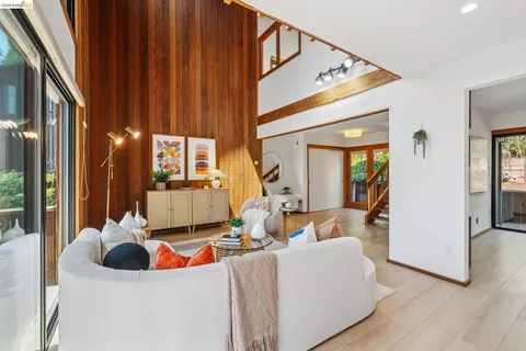 a living room with furniture kitchen view and large windows