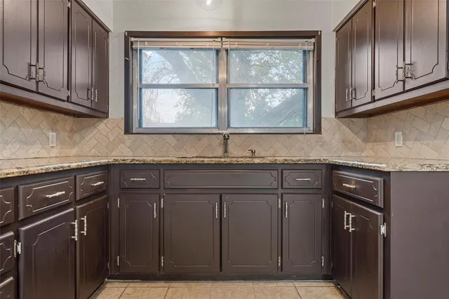 a view of an empty room with wooden floor and a ceiling fan