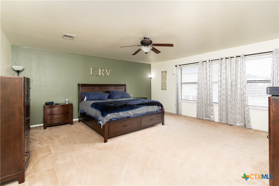 322 Fallen Leaf Lane Temple, TX 76502 - Photo 11 of 26 a spacious bedroom with a bed and a chandelier