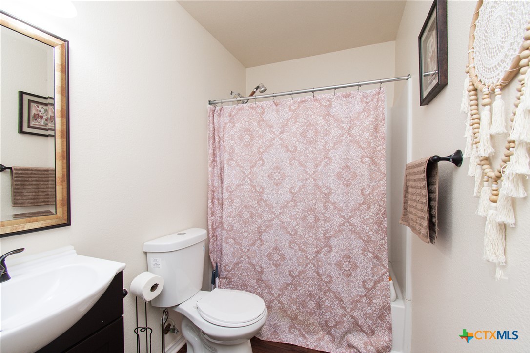 322 Fallen Leaf Lane Temple, TX 76502 - Photo 21 of 26 a white toilet sitting next to a bathroom sink