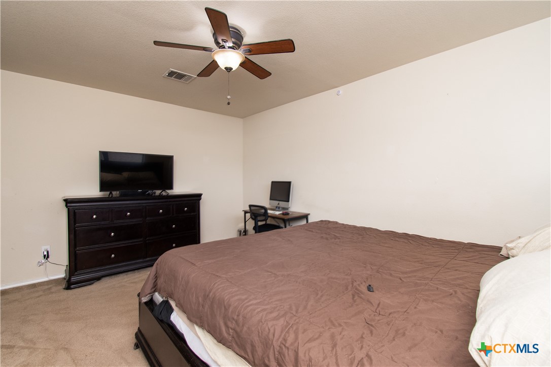 322 Fallen Leaf Lane Temple, TX 76502 - Photo 23 of 26 a bedroom with a bed and a flat tv screen on a dresser