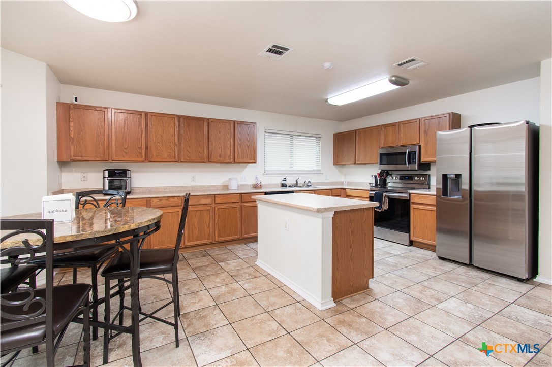 322 Fallen Leaf Lane Temple, TX 76502 - Photo 7 of 26 a kitchen with stainless steel appliances granite countertop a stove a sink a microwave a refrigerator and cabinets