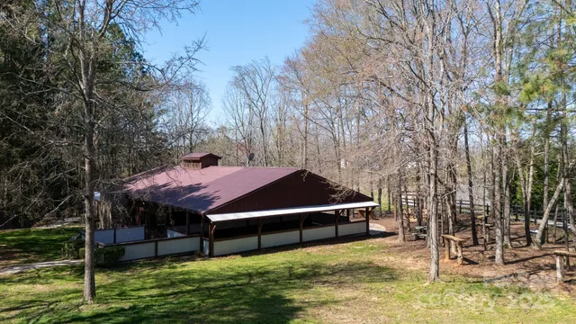 a view of a house with a yard balcony and wooden fence