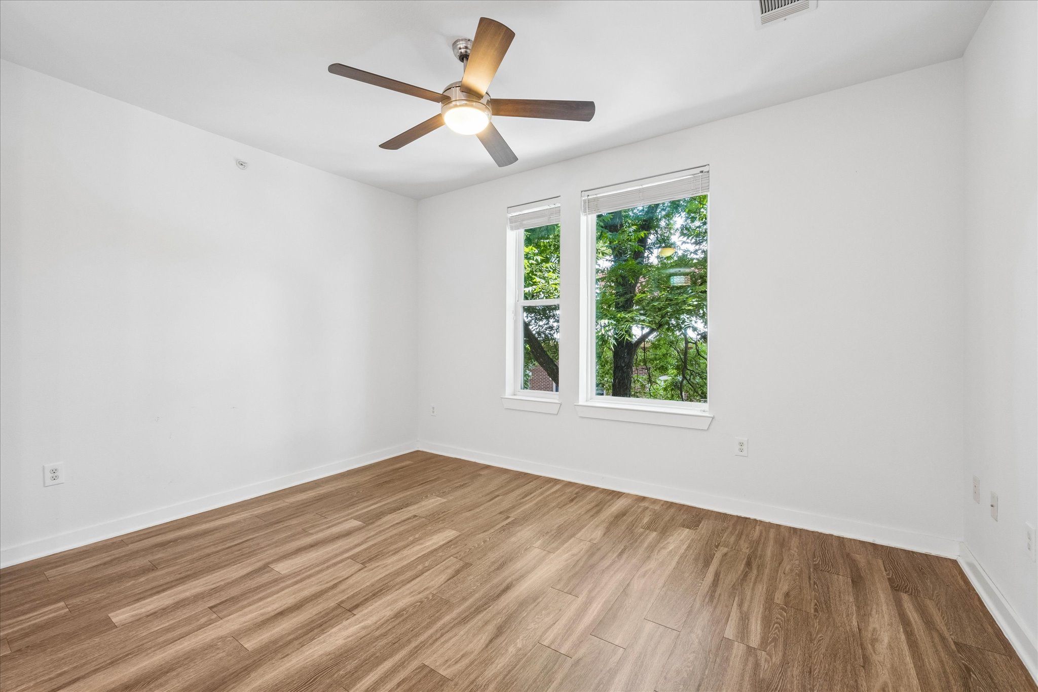1900 Barton Springs Road, Unit 4041 Austin, TX 78704 - Photo 19 of 35 Laminate flooring and a modern ceiling fan complement this inviting bedroom space.