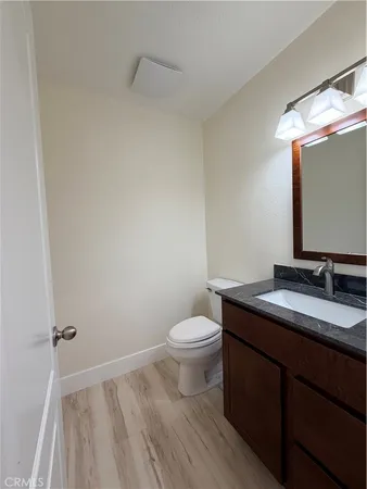 a bathroom with a granite countertop toilet sink and mirror