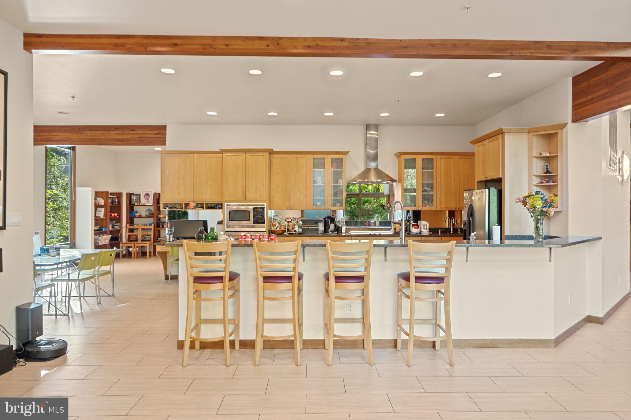 6525 76th Street Cabin John, MD 20818 - Photo 16 of 50 a dining hall with stainless steel appliances a dining table and chairs with the view of kitchen