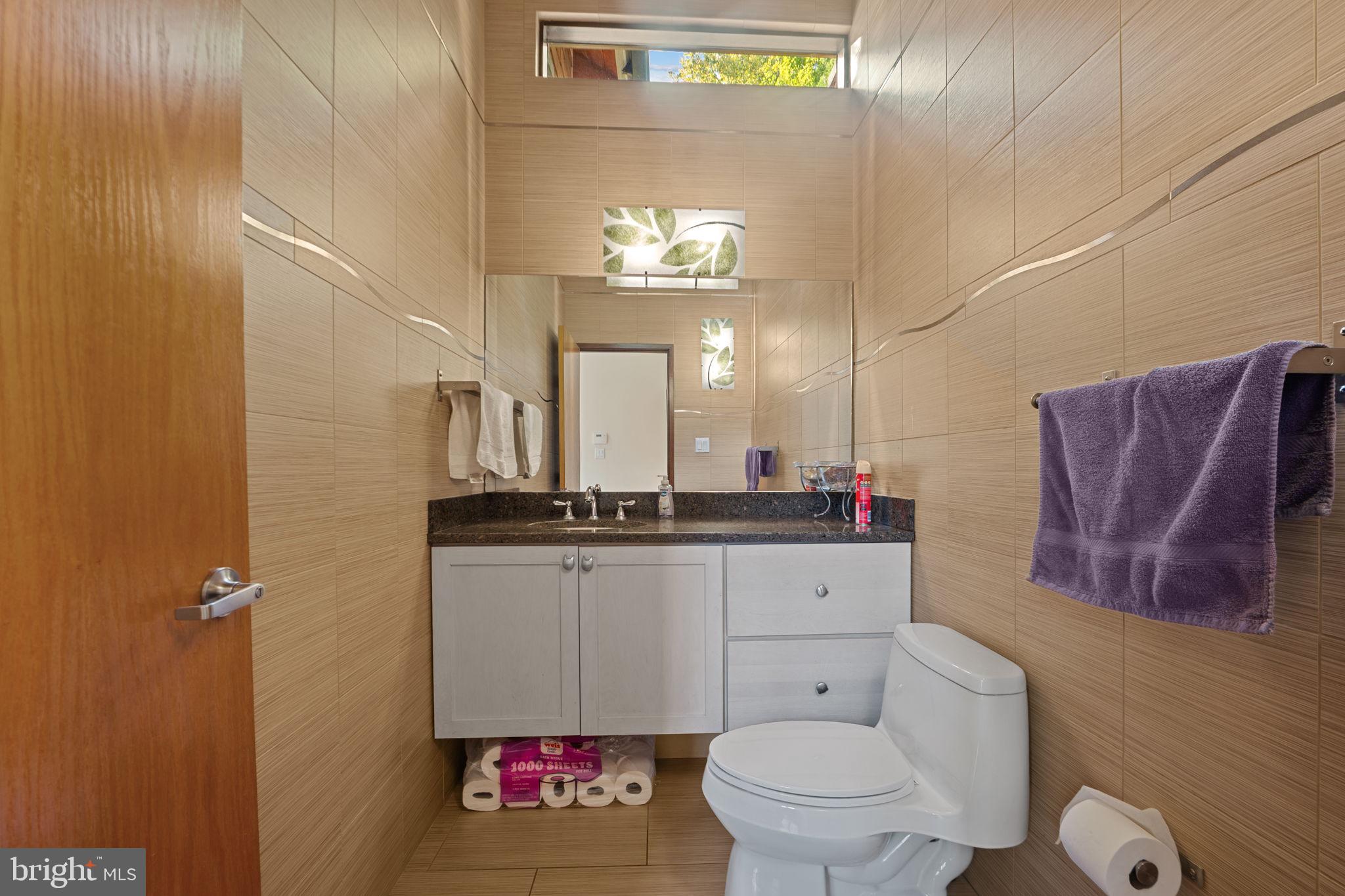 6525 76th Street Cabin John, MD 20818 - Photo 23 of 50 a bathroom with a toilet a sink and mirror