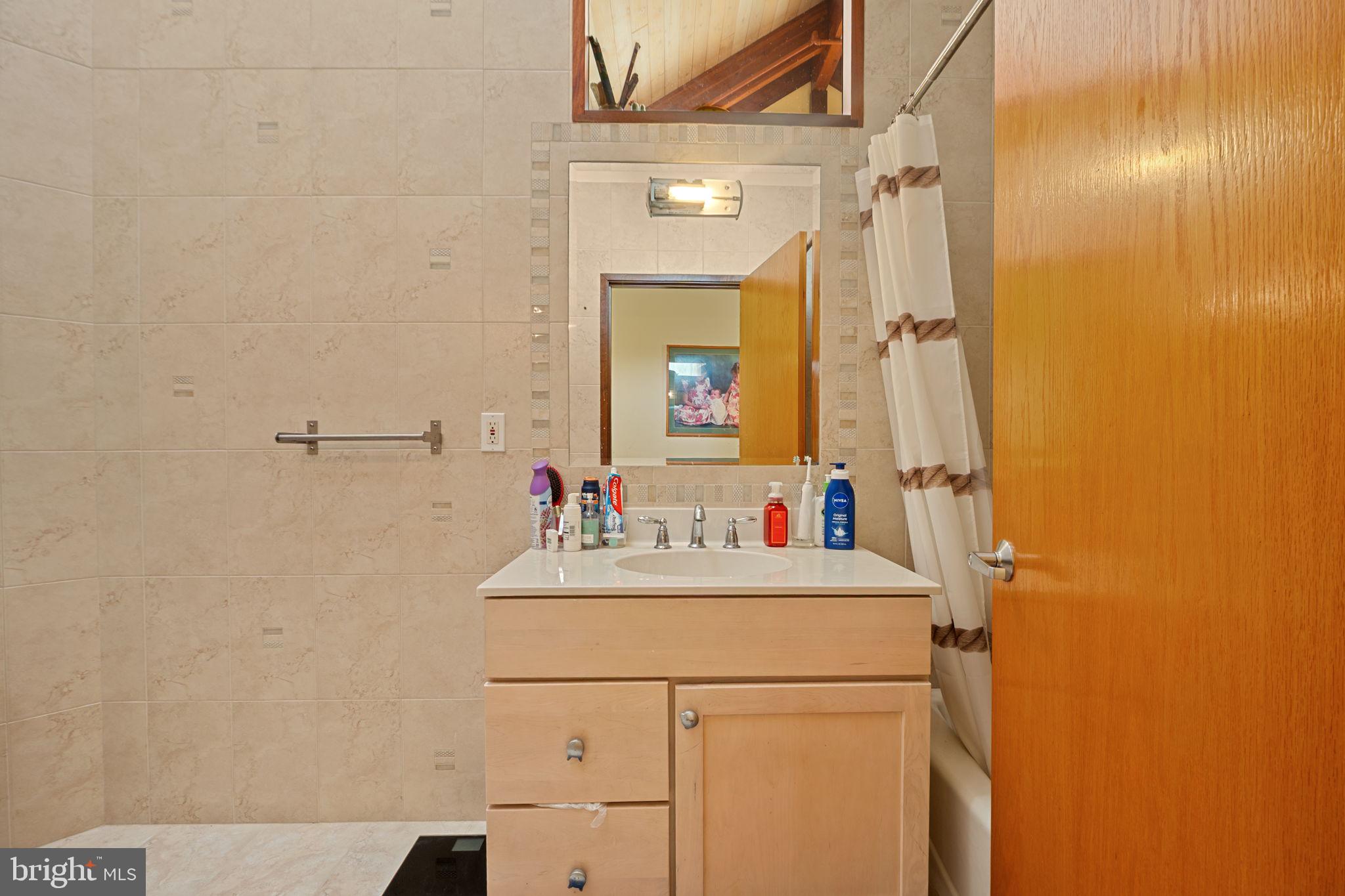 6525 76th Street Cabin John, MD 20818 - Photo 35 of 50 a bathroom with a sink and a mirror