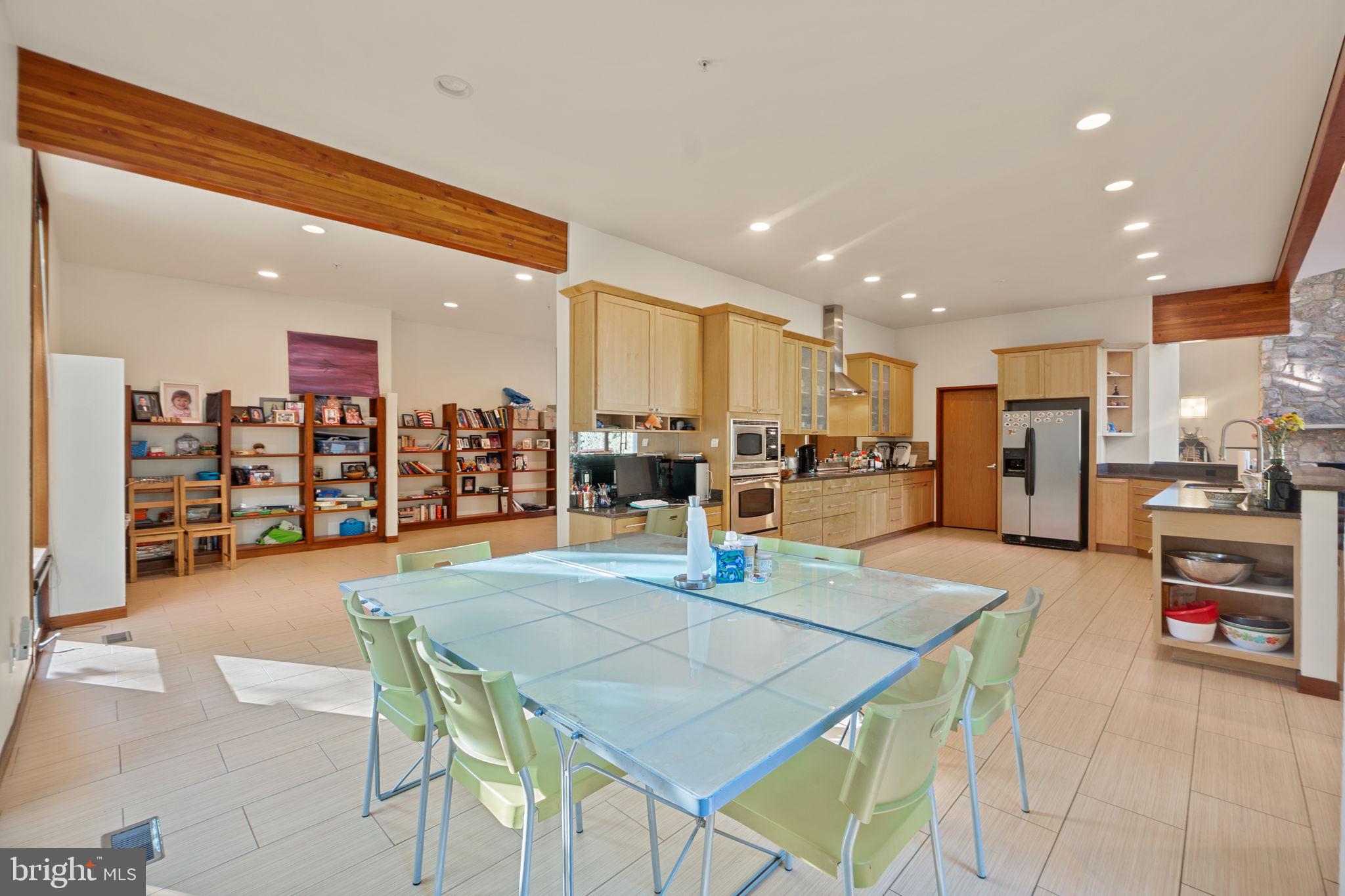6525 76th Street Cabin John, MD 20818 - Photo 10 of 50 a dining hall with stainless steel appliances kitchen island granite countertop a dining table and chairs