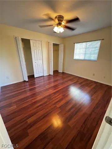 a view of an empty room and a chandelier fan