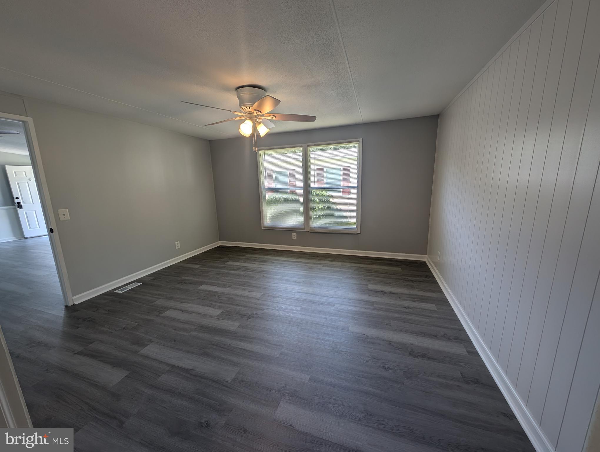 213 Poclain Road Aberdeen, MD 21001 - Photo 3 of 12 a view of an empty room with wooden floor and a window