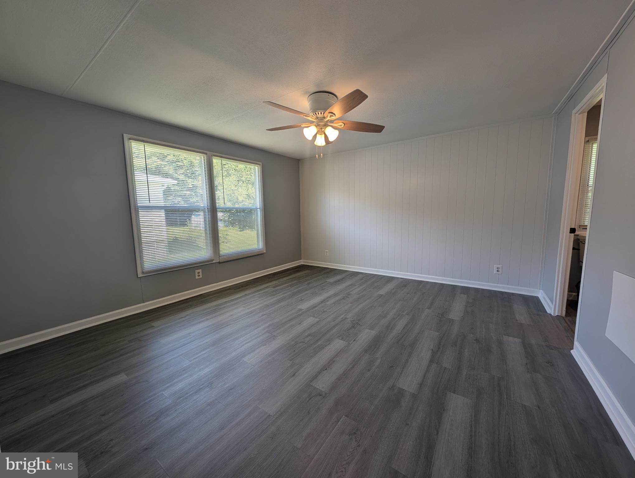 213 Poclain Road Aberdeen, MD 21001 - Photo 4 of 12 a view of empty room with wooden floor and fan