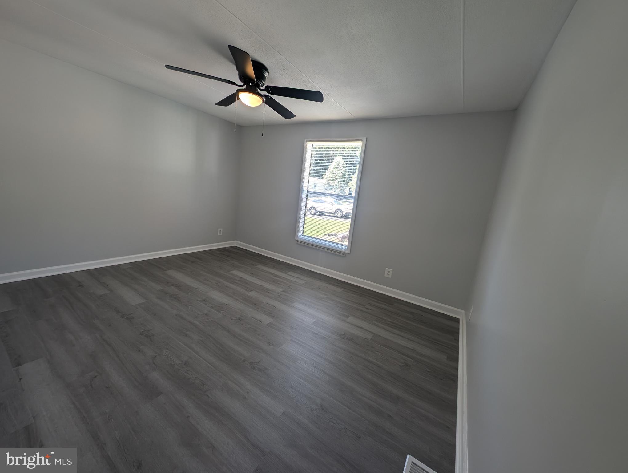 213 Poclain Road Aberdeen, MD 21001 - Photo 7 of 12 an empty room with wooden floor fan and windows