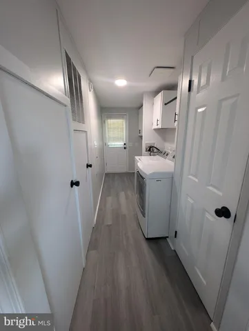 a kitchen with a sink and wooden floor