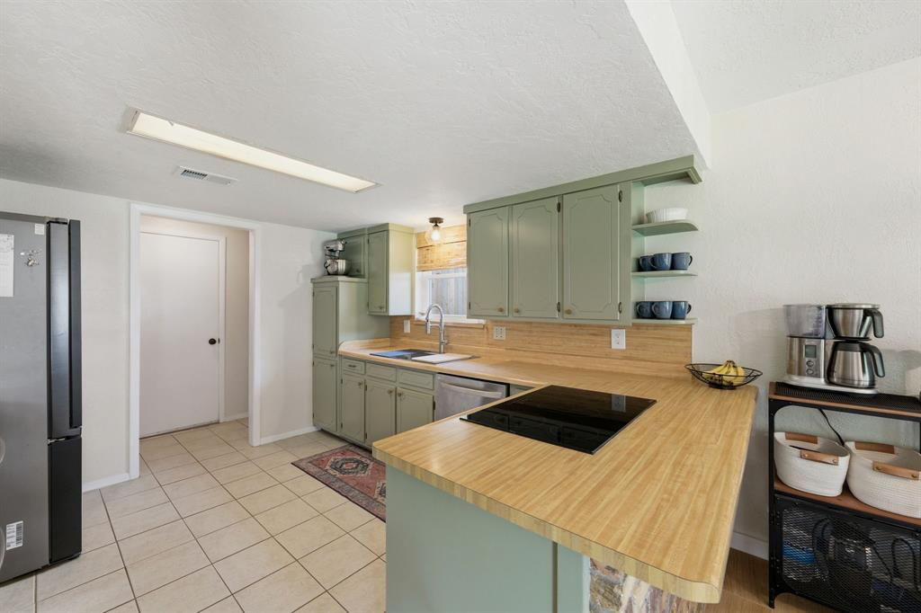 224 Overcrest Drive Benbrook, TX 76126 - Photo 13 of 39 a kitchen that has a sink a stove and a table in it