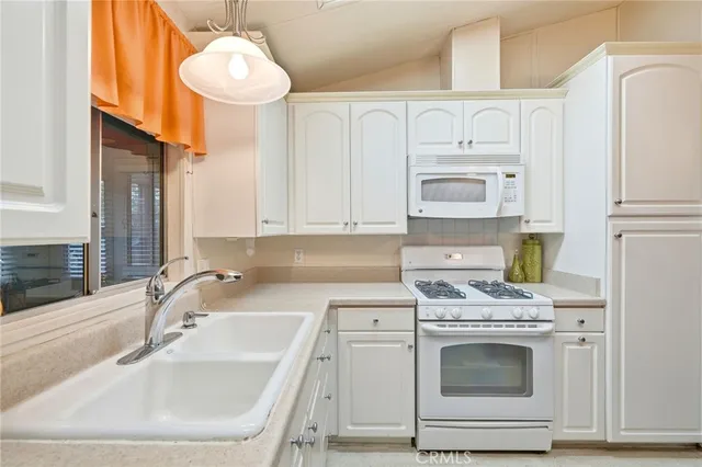 a kitchen with granite countertop a sink stainless steel appliances and cabinets