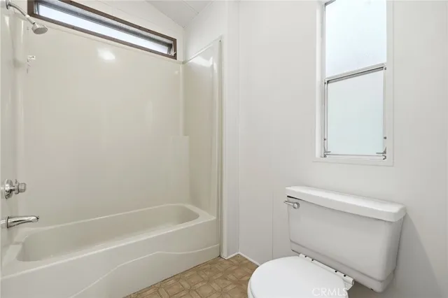 a white toilet sitting next to a bath tub