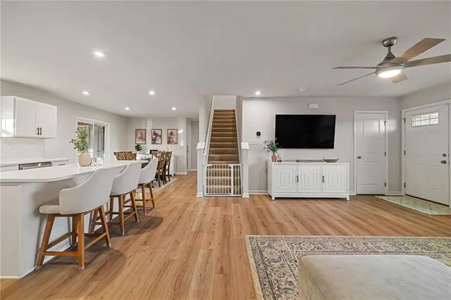 a living room with a flat screen tv a dining table and kitchen view