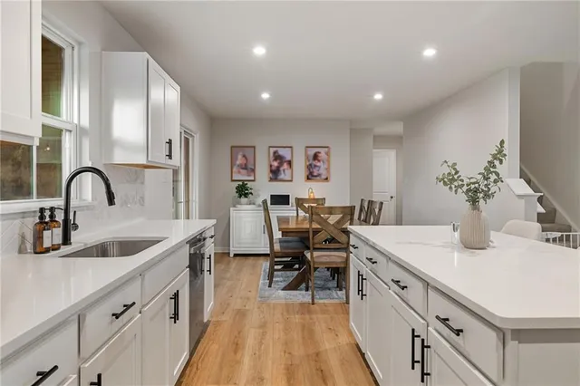 a large white kitchen with sink and dishwasher
