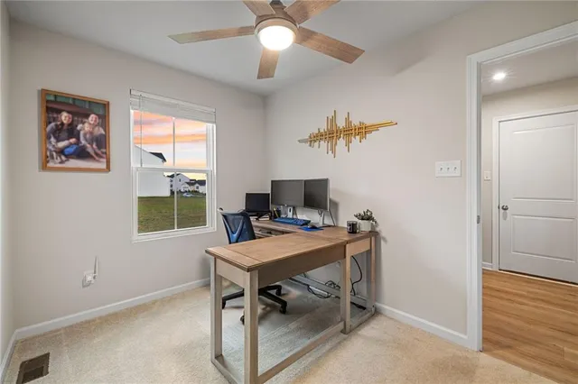 a view of a workspace with furniture and a window