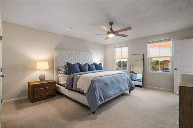 a spacious bedroom with a bed and a flat screen television