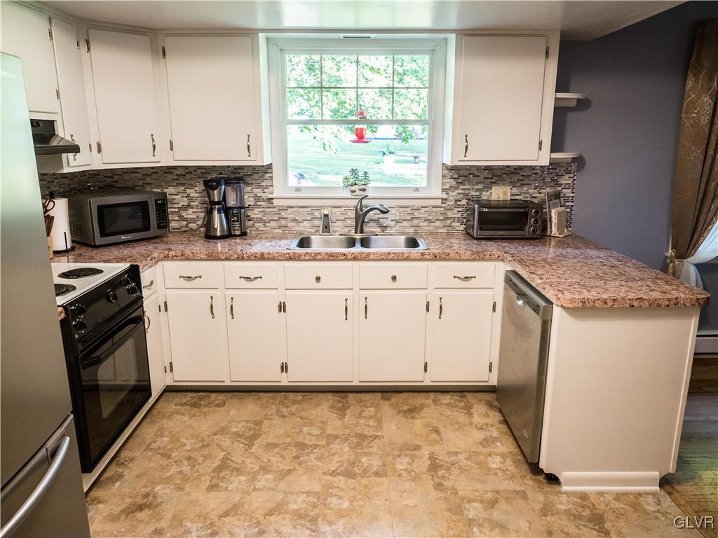 948 Engler Road Nazareth, PA 18064 - Photo 7 of 38 a kitchen with granite countertop a stove sink and cabinets