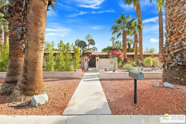 a front view of a house with a yard and fountain