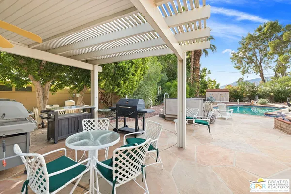a view of a patio with a table and chairs and potted plants