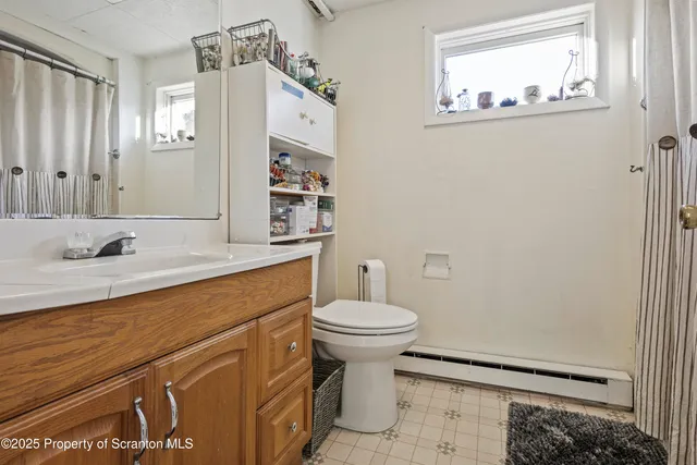 a bedroom with a bed potted plant on the dresser and a chandelier