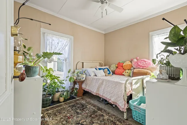 a bedroom with a bed table and a potted plant
