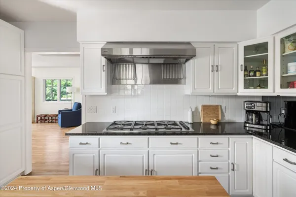 a kitchen with granite countertop a stove and cabinets