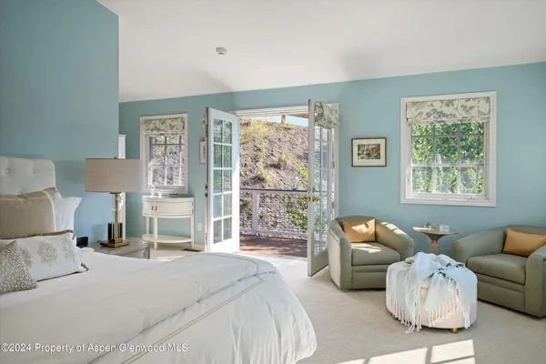 a bedroom with a bed and a couch next to a window