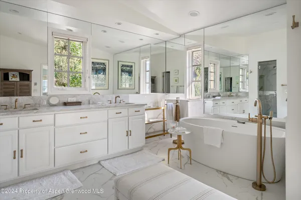 a bathroom with a tub sink and mirror