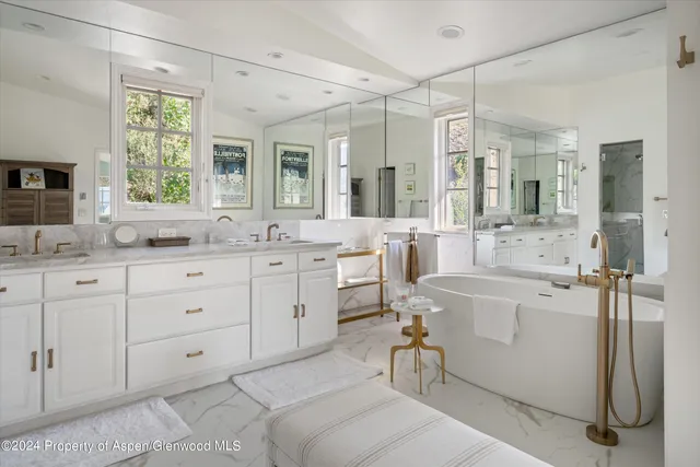 a bathroom with a tub sink and mirror