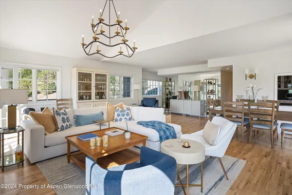 a living room with furniture a table and a large window