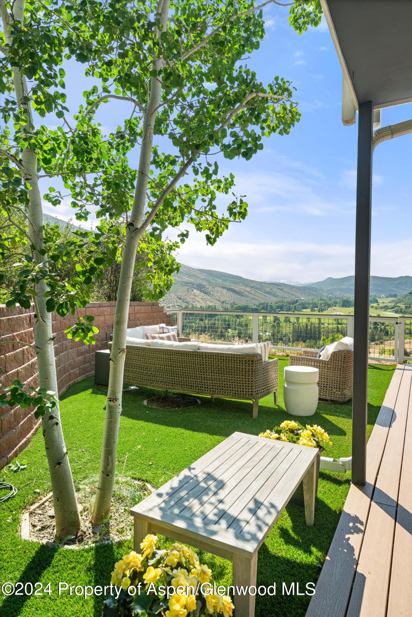 407 Gateway Road Snowmass, CO 81654 - Photo 35 of 37 a view of a patio with lawn chairs floor to ceiling window and yard