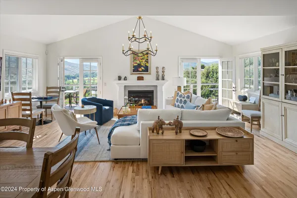 a living room with furniture a fireplace and a chandelier