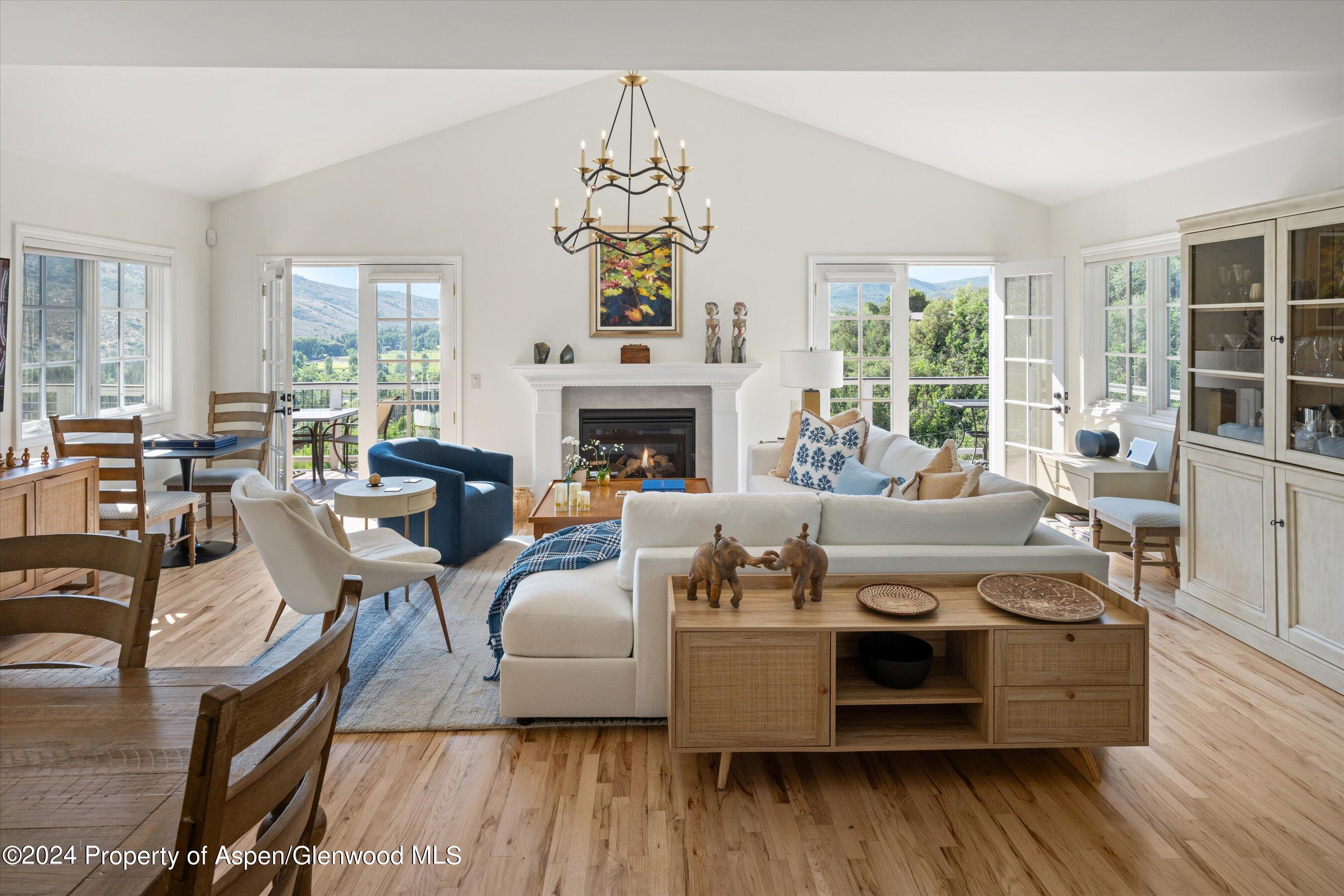 407 Gateway Road Snowmass, CO 81654 - Photo 4 of 37 a living room with furniture a fireplace and a chandelier