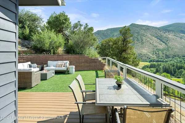 a balcony with wooden floor table and chairs