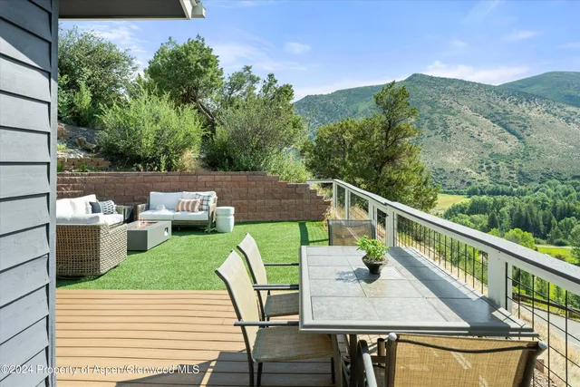 a balcony with wooden floor table and chairs