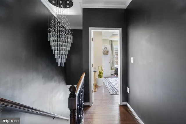 a view of a hallway with wooden floor and stairs