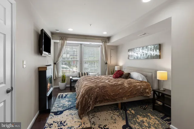 a bedroom with a bed window and flat screen tv