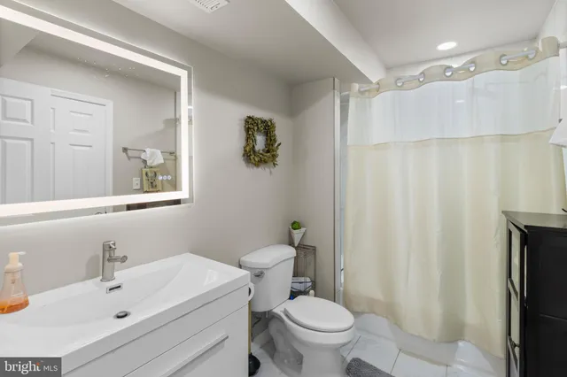 a bathroom with a sink a toilet and shower curtain