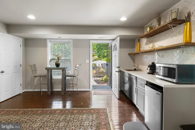 a kitchen with a table chairs microwave and cabinets
